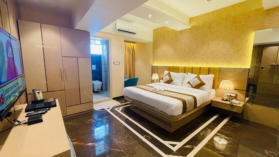 A king bed with TV opposite to it inside Deluxe Suite Room - Home2 Renaissance Club Hotel