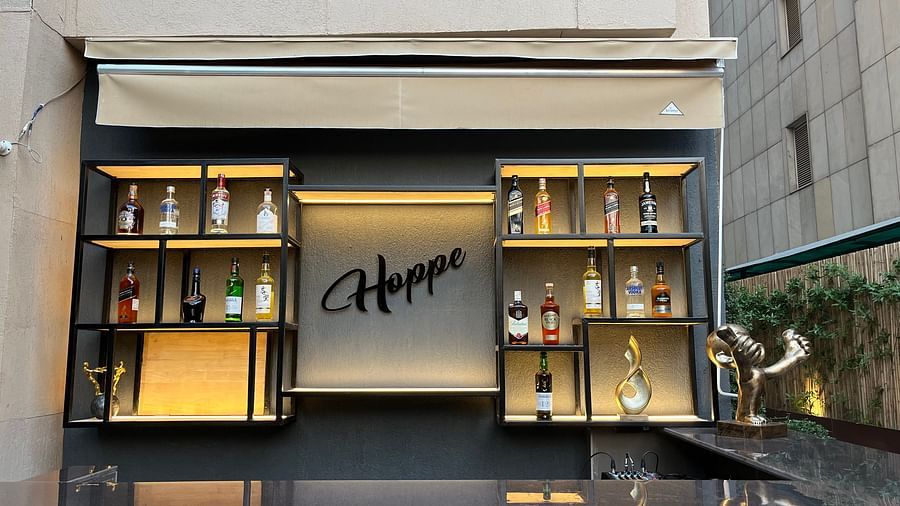 The bar area at Nemesia is visible with shelving, a counter, and the word Hoppe.