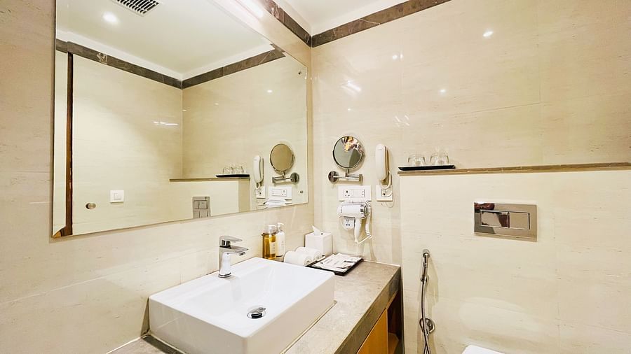 Modern bathroom at Nemesia with a stylish sink and mirror with warm lights.