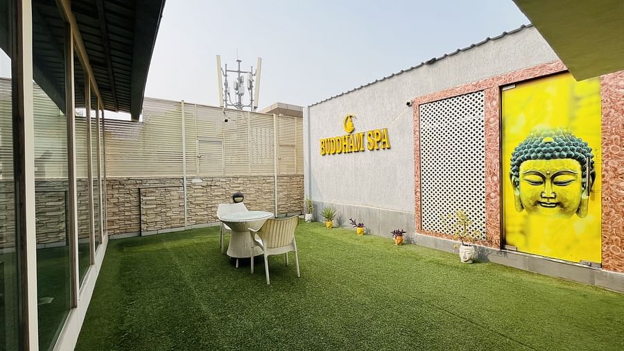 Outdoor seating area at Nemesia with lush greenery and a vibrant mural.