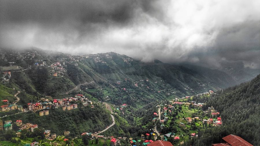 an overview of the town of Shimla with dark clouds above it 