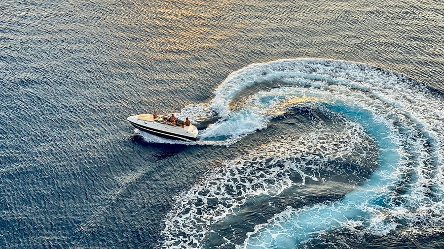 a speedboat taking turns in the sea, making an intricate effect in the water
