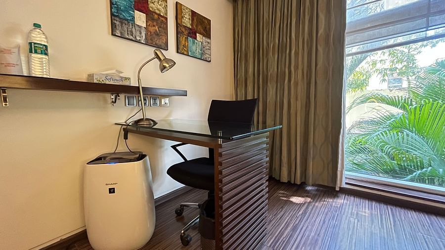 a posh bedroom showcasing a workdesk chair couch air purifier mineral water bottle - yuhi Mansions3
