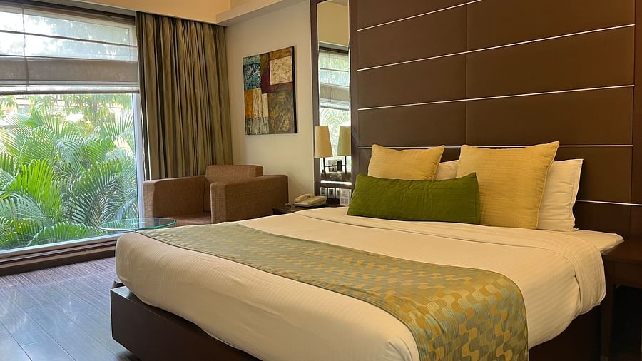 a posh bedroom with luxurious interior along with king size bed soft pillows white linens and the room also features a ceiling-to-floor windows1