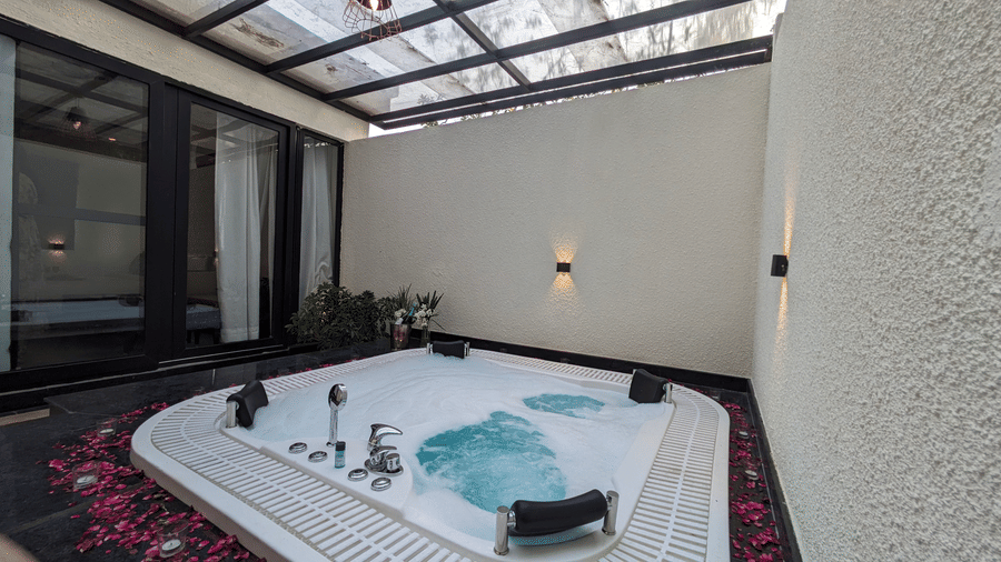 Jungle Spring Villa Private Hot Tub bathroom with a large, rectangular jacuzzi tub under a glass roof at The Golden Tusk, Jim Corbett
