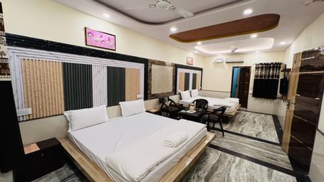 A large hotel room with two beds, a sofa, and modern decor, providing ample space for guests. | Family Room | Hotel City Palace DX