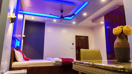 Room with blue and purple accent lighting, double bed and seating area - Luffu Club