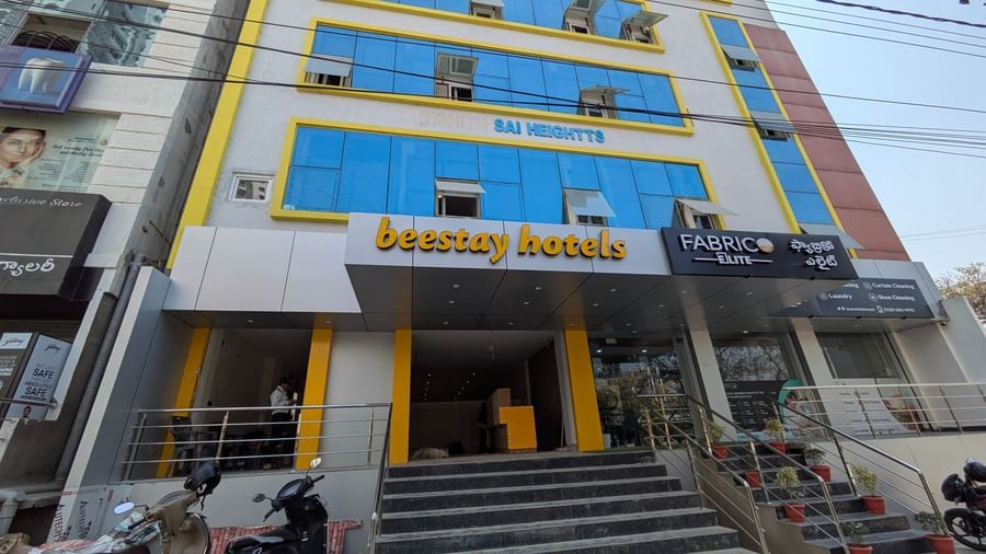 Close up  view of a multi-story building with blue-tinted windows and Beestays Hotels written on the facade - Beestay Hotels Financial District, Hyderabad 