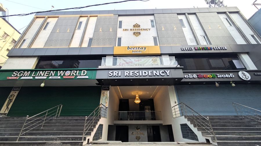 Facade view with signage and entrance with stairs at Beestay Hotels, Rajahmundry.