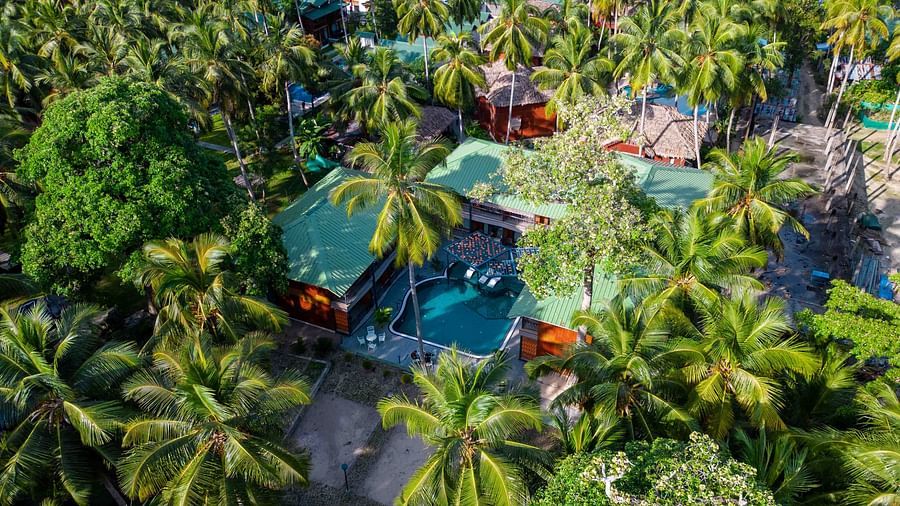  An overhead view of the resort with its beach and several facilities, including swimming pools and tropical gardens. The landscape showcases the resort’s integration with nature - Coral Reef Resort & Spa, Havelock