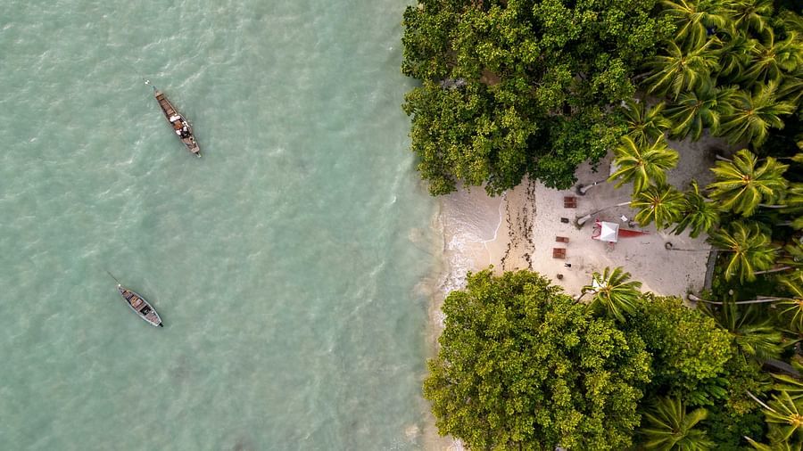  A bird's-eye view of kayaks on calm, clear waters near a beach. The lush greenery surrounding the beach adds to the peaceful atmosphere of the area - Coral Reef Resort & Spa, Havelock