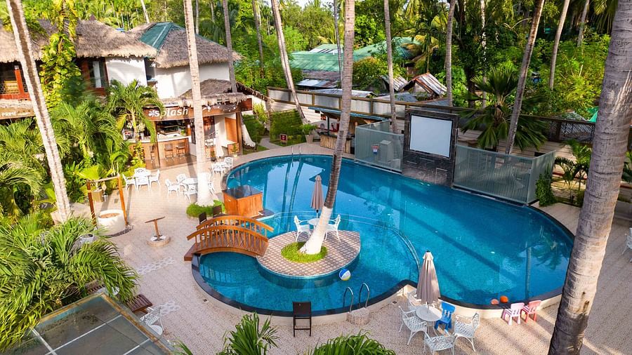 A bird's-eye view of the resort with pools, gardens, and modern facilities. The tropical setting includes palm trees and lounge areas, enhancing the resort's natural appeal - Coral Reef Resort & Spa, Havelock