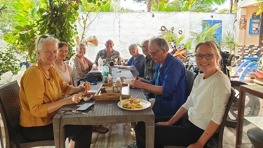 A group of tourists having a good time as they are seated on a dining table at the Dream Vision Guest House.