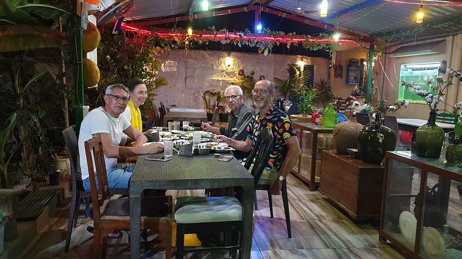 Few guests smiling towards the camera as they are sitting in the dining area of the Dream Vision Guest House.