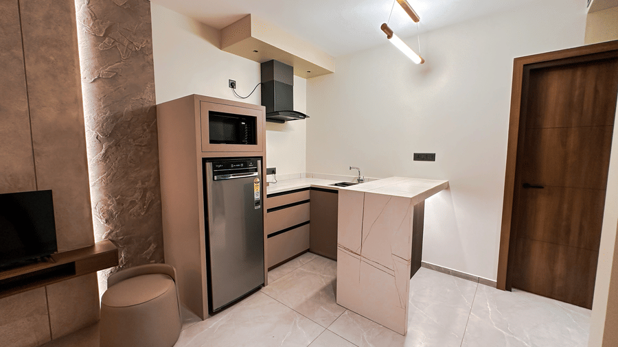 The kitchenette well-equiped with a medium single-door refridgerator and a microwave in the Apartment Suite of F Hotels, Bengaluru.