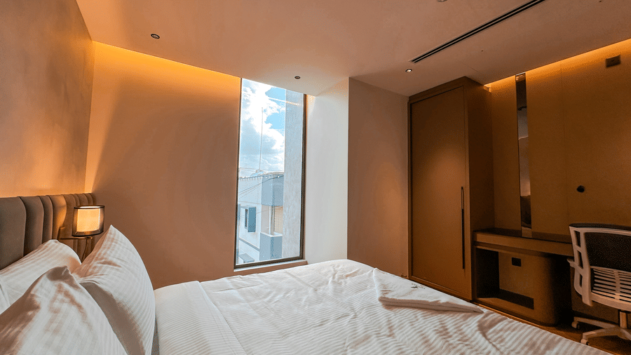 An overhead shot of the Executive Room featuring a double bed overlooking city views from the big windows at F Hotels, Bengaluru.