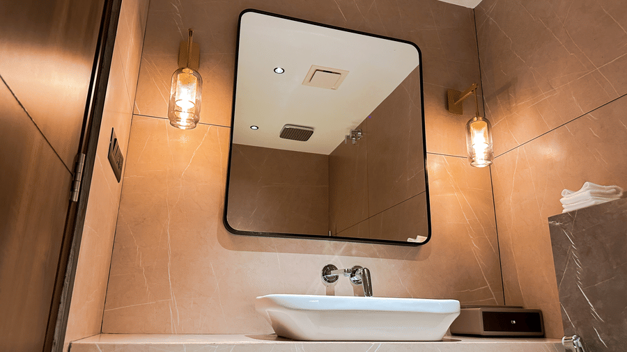 Close up of the wash basin with a square mirror above it in the bathroom of the Executive Room at F Hotels, Bengaluru.