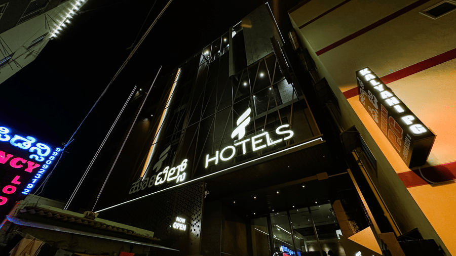 The entrace of F Hotels, Bengaluru, featuring its signboard outside the building during the night.