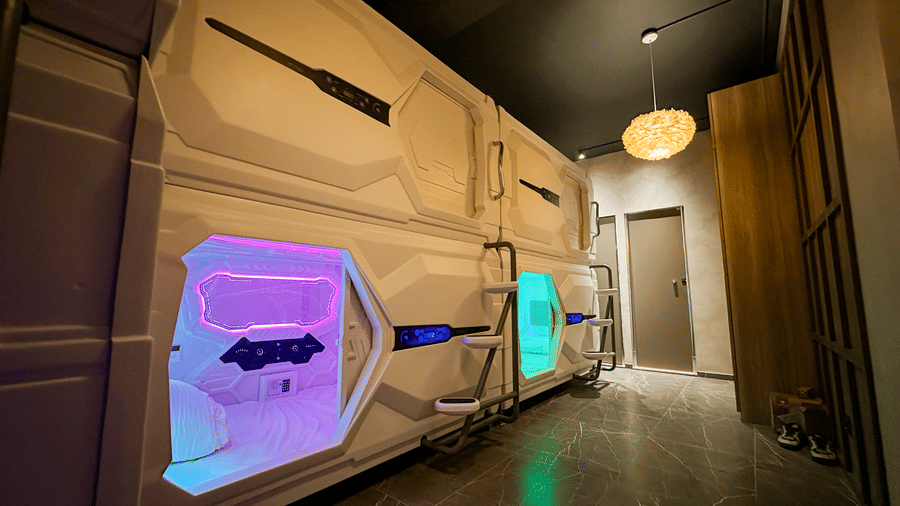 The exterior of the cluster of pods at F Hotels, Bengaluru, with a door at the far end of the room opening to the common washroom.
