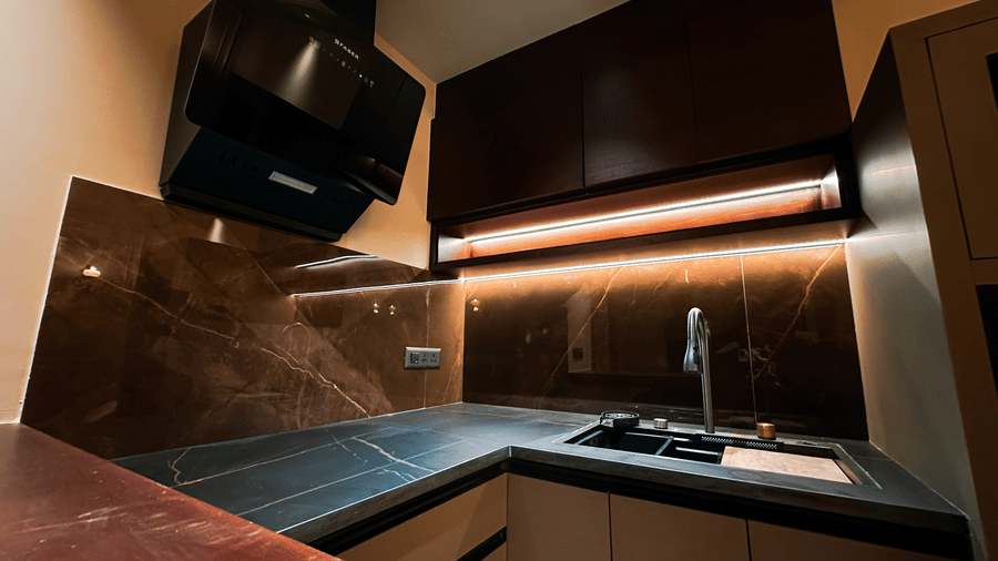 The kitchenette in the Presidential Suite with a black countertop at F Hotels, Bengaluru.