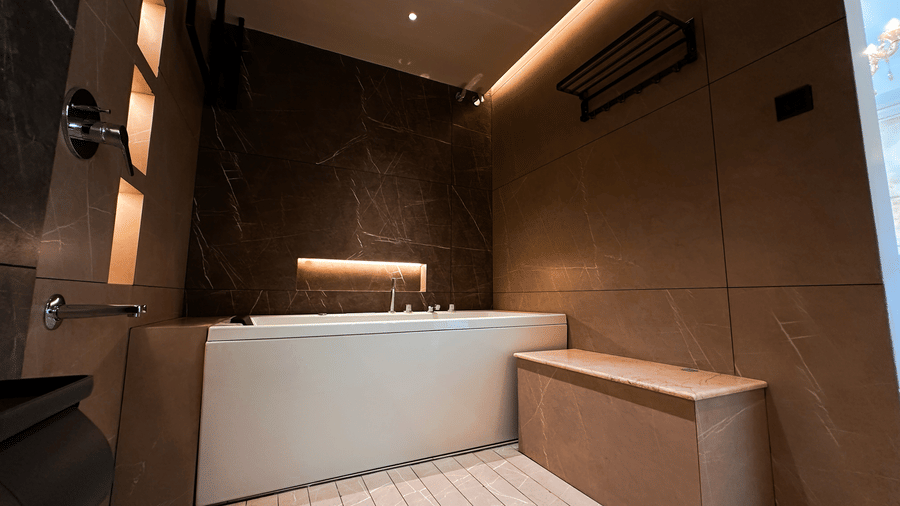 A full-length bathtub at the bathroom of the Presidential Suite of F Hotels, Bengaluru, featuring beautiful interiors with gradient tiles.