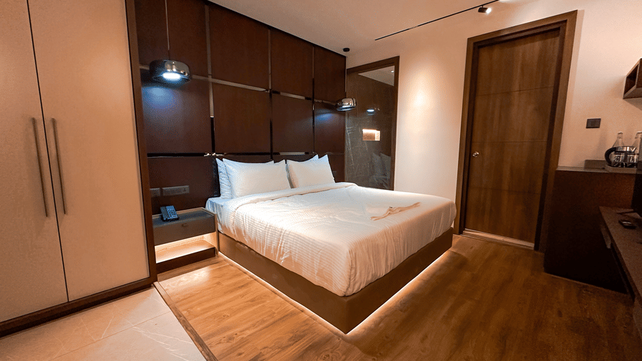 Full view of a plush double bed at the Superior Room with wooden flooring at F Hotels, Bengaluru.