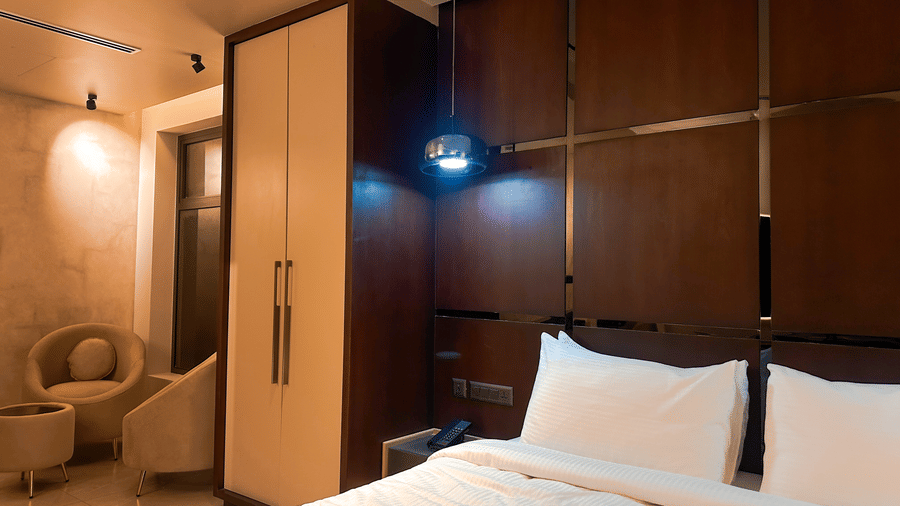 The wordrobe in the Superior Room beside the double bed, overlooking the common seating area in the corner at F Hotels, Bengaluru.