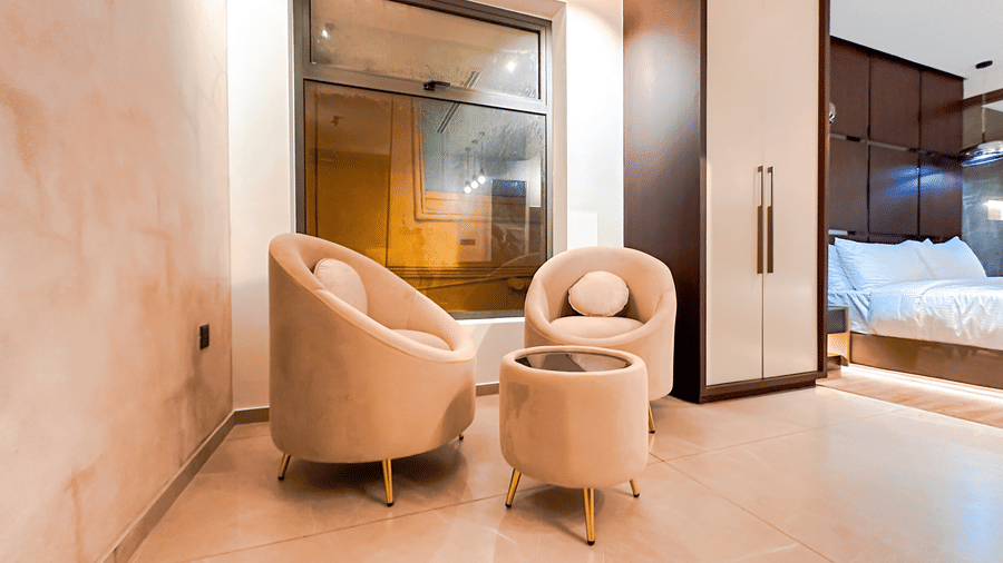 Common seating area in the Superior Room with 2 cushioned arm chairs along with a small coffee table at F Hotels, Bengaluru.