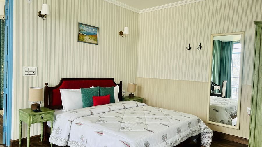 An image of a bed room with bed that has cushions, a mirror near the bed  | Faraway Cottages, Auli