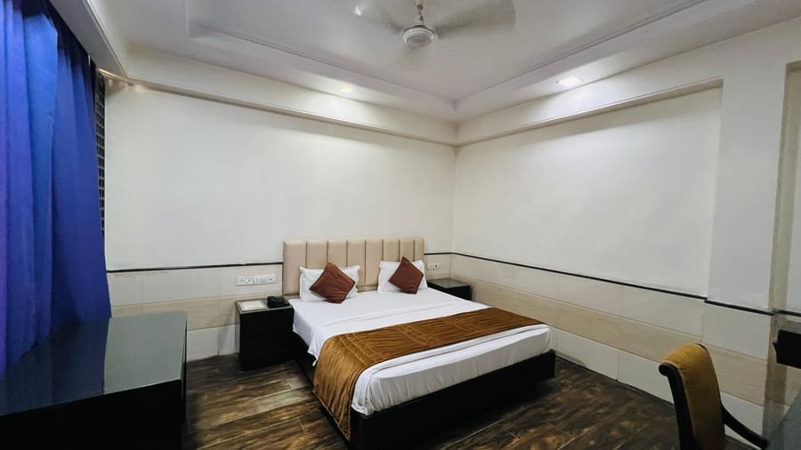  stylish hotel suite featuring a comfortable bed, an ornate rug, and ample space, perfect for a restful stay. | Suite | Hotel Aadhar