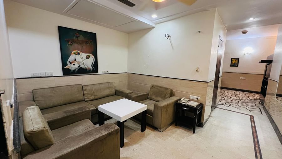 A spacious hotel suite with a large sectional sofa and a coffee table, designed for comfort and group gatherings. | Suite | Hotel Aadhar