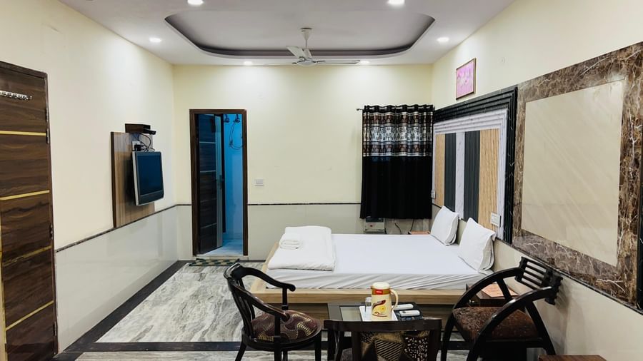A hotel room with two beds and a seating area, designed for comfort and functionality. | Family Room | Hotel City Palace DX