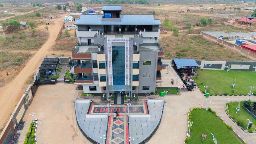 Aerial view of a multi-storey building with a unique facade and patterned forecourt - Luffu Club