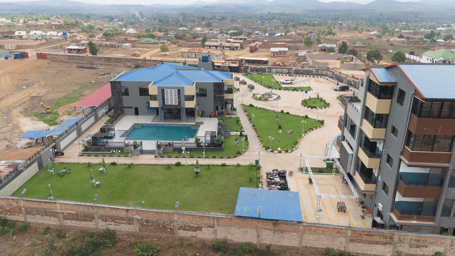 Aerial view showing a multi-storey building, swimming pool, and surrounding area - Luffu Club