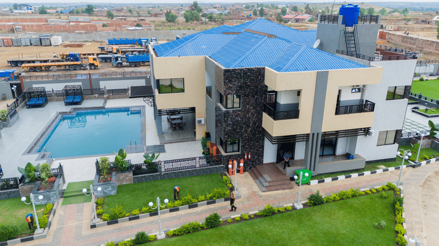 Aerial view of a large modern building with a swimming pool and well-maintained grounds - Luffu Club