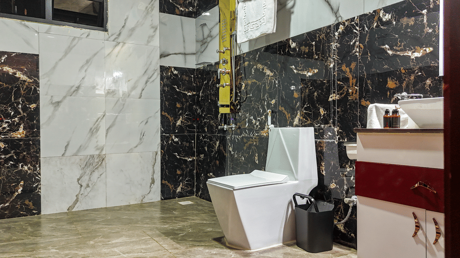 Interior view of a modern bathroom with marble-style tiling, a water closet, and a sink vanity - Luffu Club