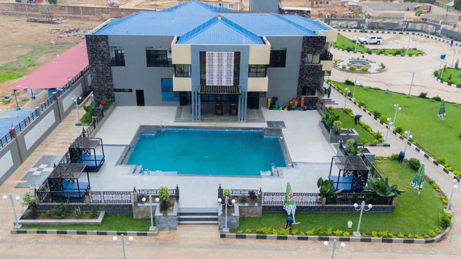 Aerial view of a modern building with a swimming pool and landscaped grounds at Luffu Club