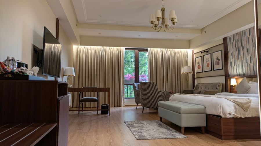The Premium Room at M2 Square by Monday Premium featuring a double bed with the curtains slightly opened showcasing the lush green views from the huge windows.