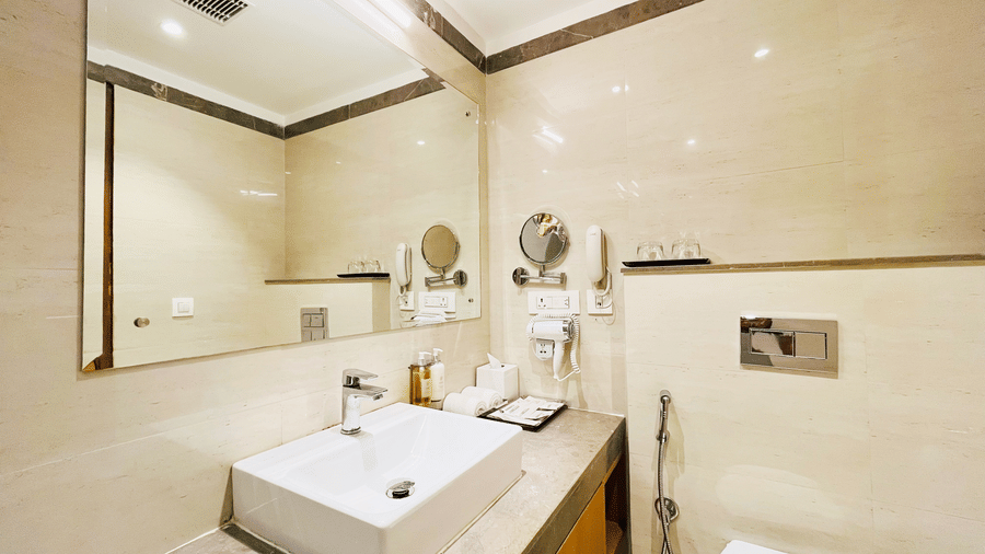 Modern bathroom at Nemesia with a stylish sink and mirror with warm lights.