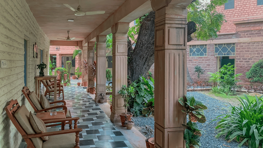 Traditional veranda seating area at Polo Heritage, Managed by Trance, Jodhpur with wooden chairs and garden views.