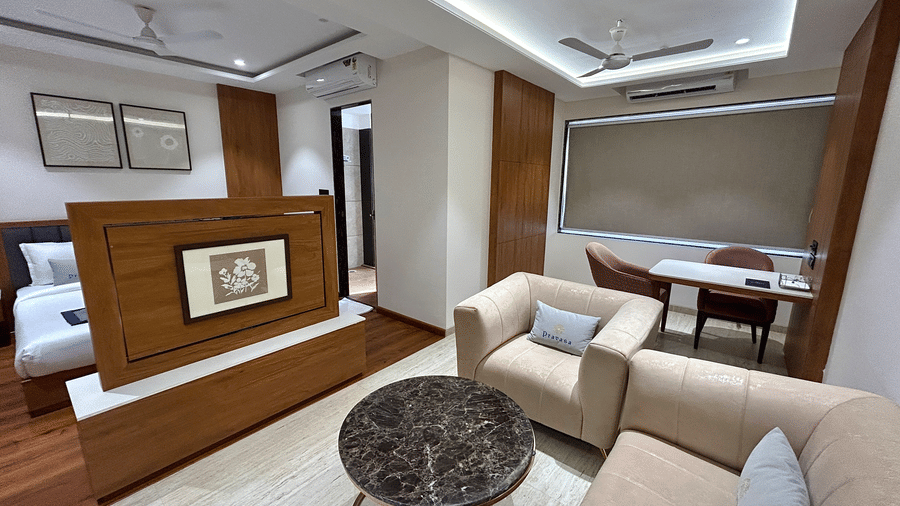 A seating area in an expansive room at Pravasa Stay Bapat Square, Indore featuring sofas and a dining area as well.