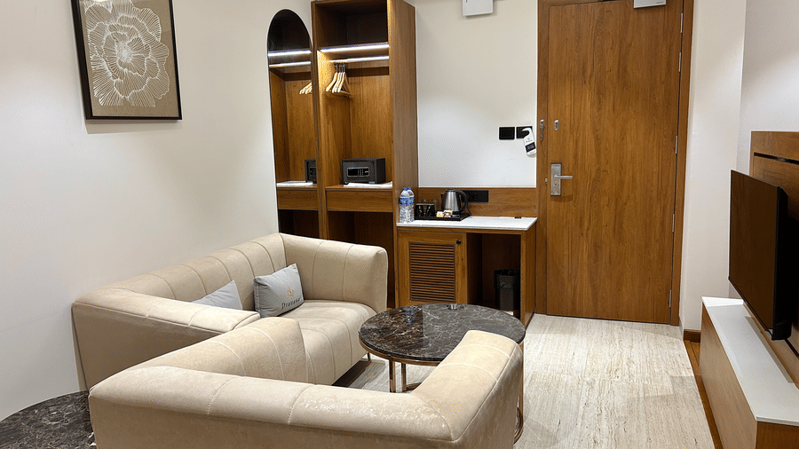 A comfortable seating area within a suite featuring a modular sofa and a view of the entryway at Pravasa Stay Bapat Square, Indore.