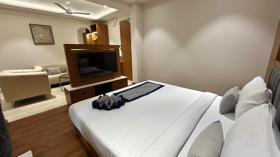 A sophisticated suite layout showing the proximity between the sleeping area and the lounge space with a TV divider at Pravasa Stay Bapat Square, Indore.