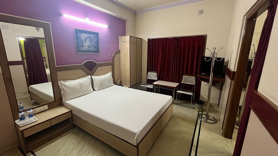 image of the superior room featuring a double bed against a lavender coloured wall in the background at grand krishna rooms in bengaluru