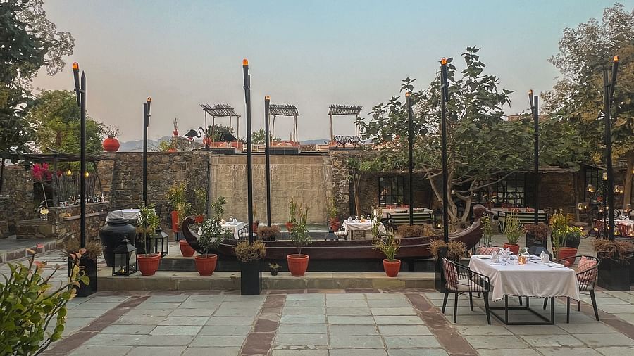 An image of an outdoor seating at the hotel with trees around - Utsav Camp Sariska