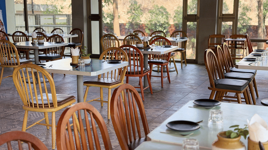 The restaurant at Vinti Resort, Ambaji, warmly lit for dinner, and comfortable tables set for dining.