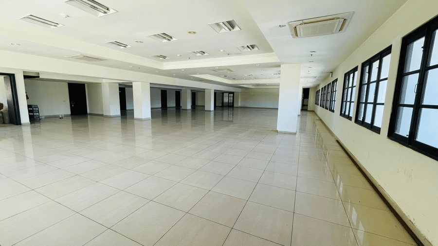 An interior view of Raj Darbar Hall with tiled floor, rows of windows and pillars.
