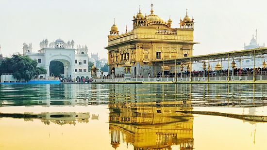 Facade of the Golden Temple featuring its reflection on the lake