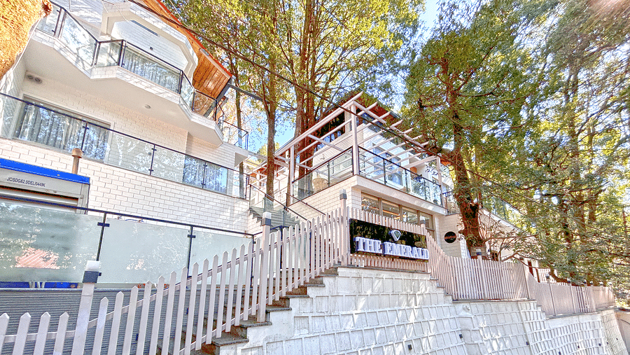 A facade image of DLS The Emerald, Nainital surrounded by tress and lush greenery