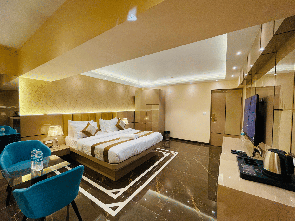 Another view of the king bed next to sofas inside Suite - Home2 Renaissance Club Hotel